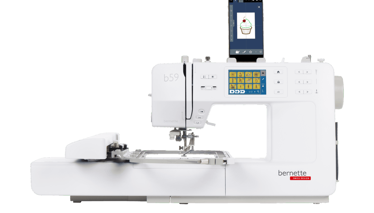 Official manufacturer image of the bernette 59 sewing-and-embroidery machine with the embroidery module attached, touchscreen visible and a smartphone showing a design screen; it does not depict every included or optional accessory.